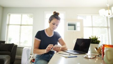 Young woman looking at budget on phone