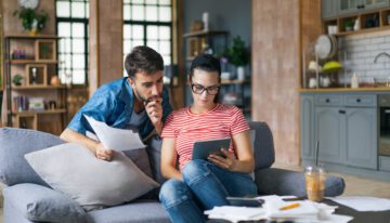 Couple with bad credit looking at paperwork to refinance student loans.