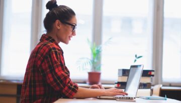 Woman working on computer and looking up the statute of limitations on student loans.