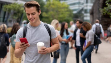 male college student checking credit score on mobile phone