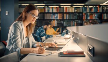 young female college student studying in university library