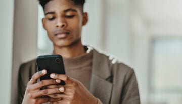 Man looking at new student loan news on phone