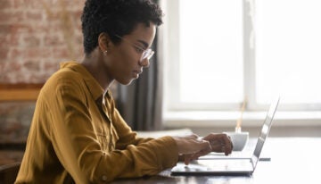 Female student researching the Save for a valuable education plan on their laptop.