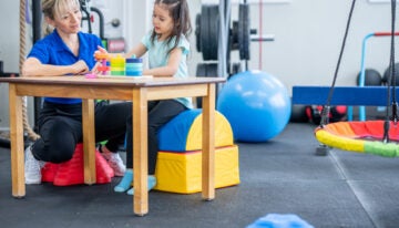 Occupational therapy student who used occupational therapy scholarship for school helping a child with therapy.