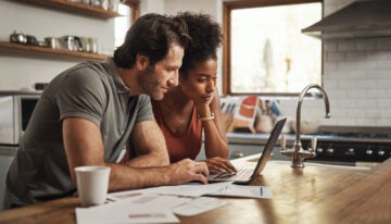 Young couple looking over student loan debt before marriage.