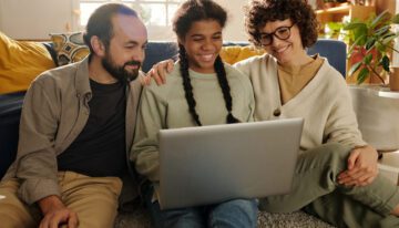 Parents and child looking at the FAFSA changes on a laptop at home.