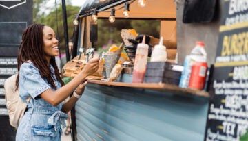 Young woman purchasing from a food truck with a card