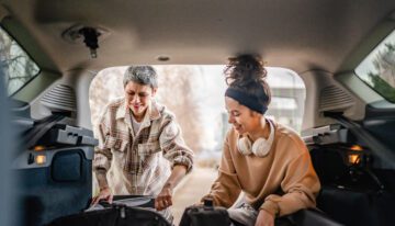 Smiling mother and daughter pack up car