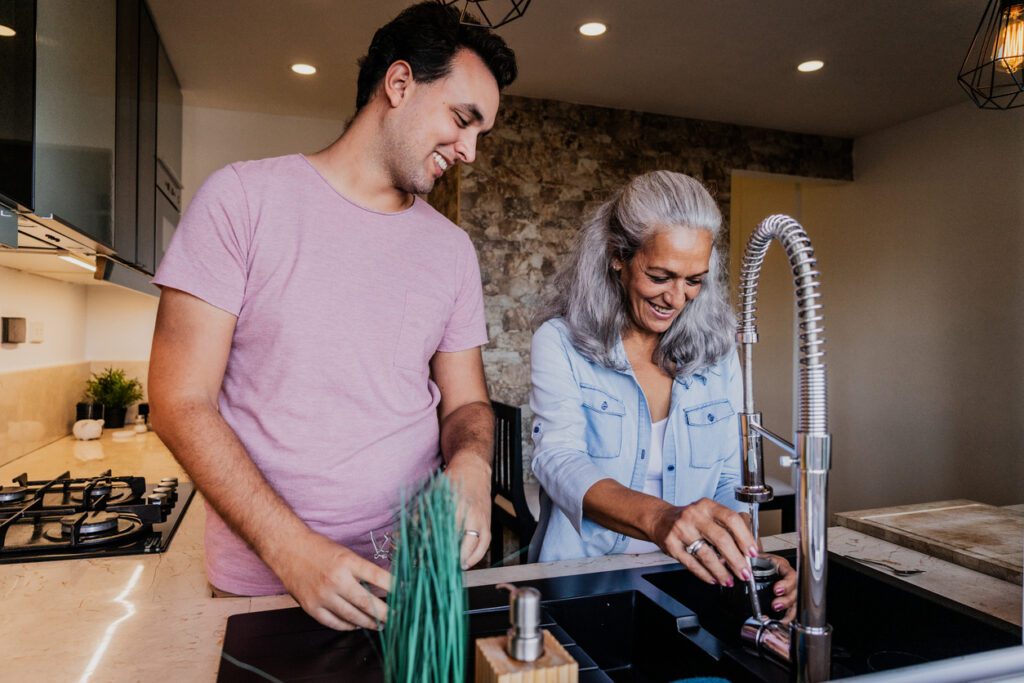 Mother and son talking and preparing coffee in the kitchen at home