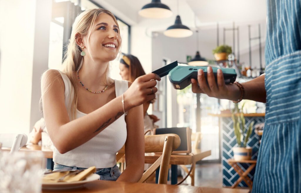 Young woman using a card with a cashier