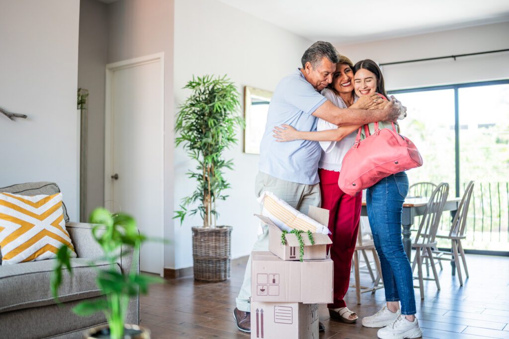 Young woman leaving parent's house and they embracing