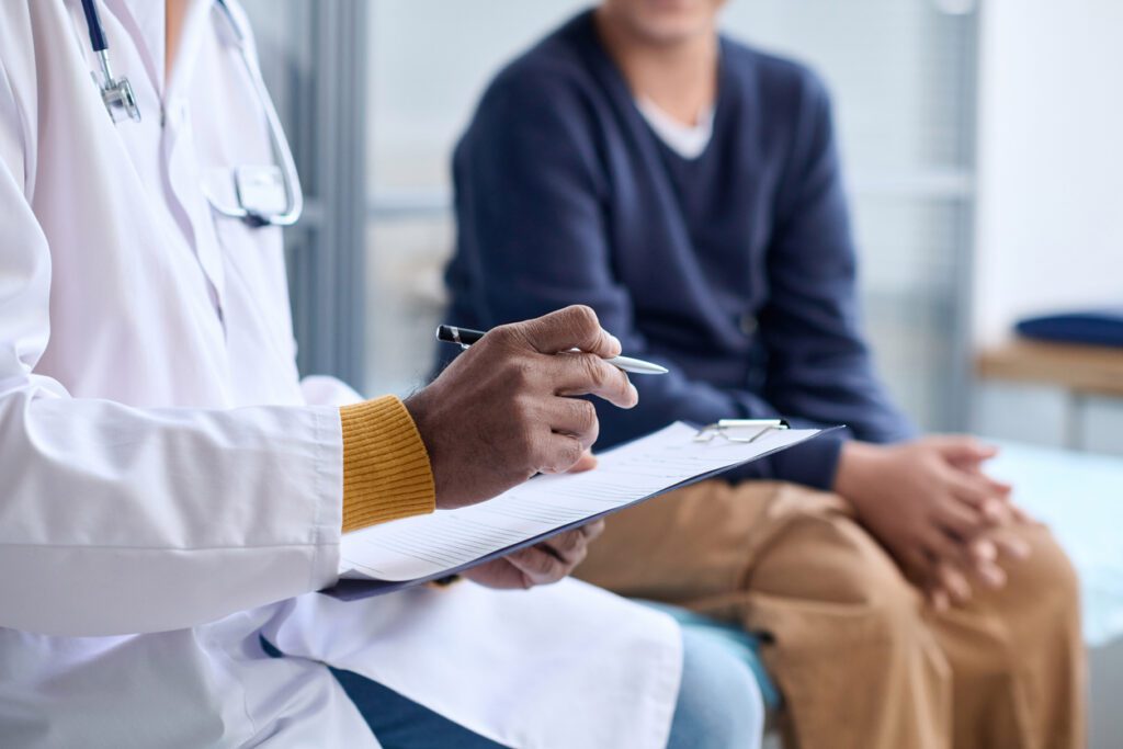 Side view closeup of doctor holding clipboard while consulting child in clinic copy space