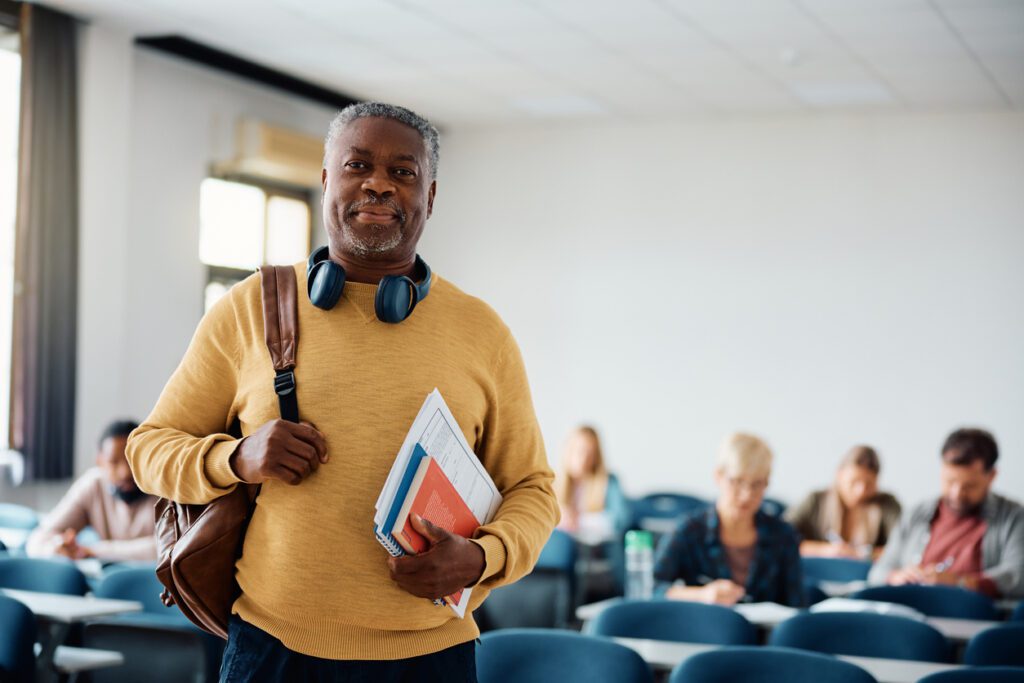 Portrait of smiling senior student in the classroom looking at camera. Copy space.