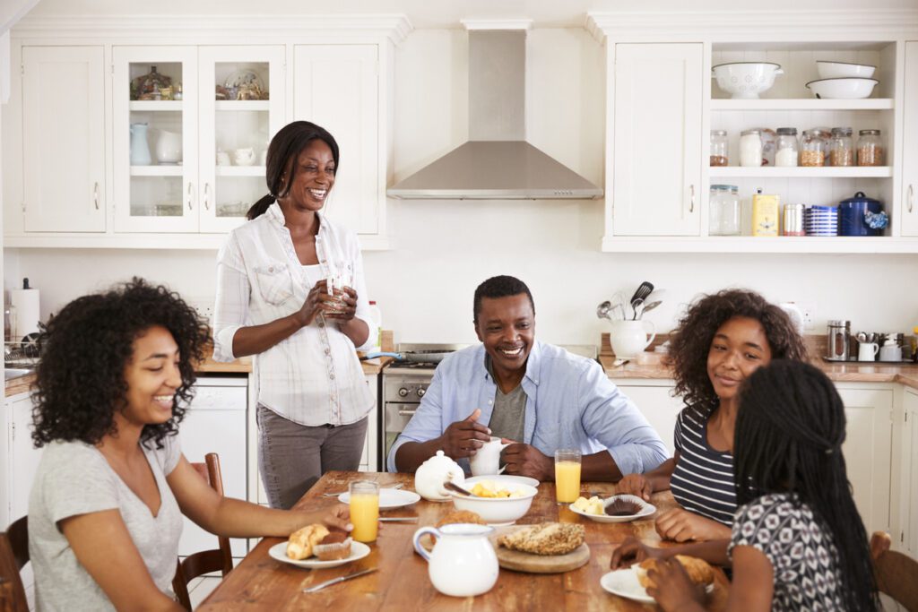 Family With Teenage Children Eating Breakfast In Kitchen