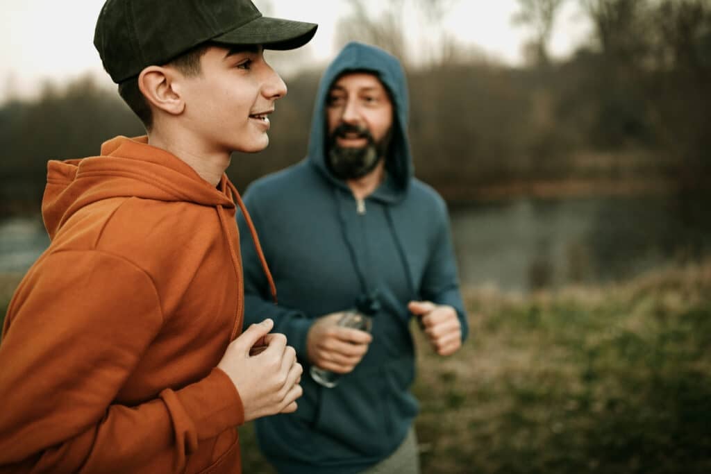 Mature man and his son running in the public park