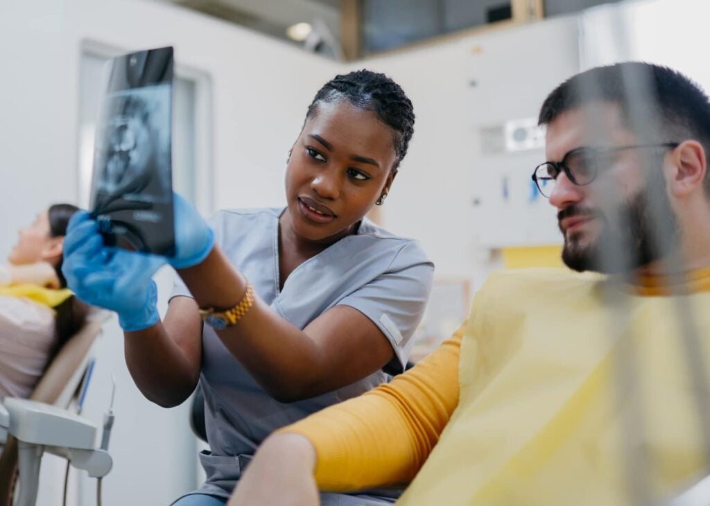 Positive team of dentists checking the X-ray of a patient in their dental office