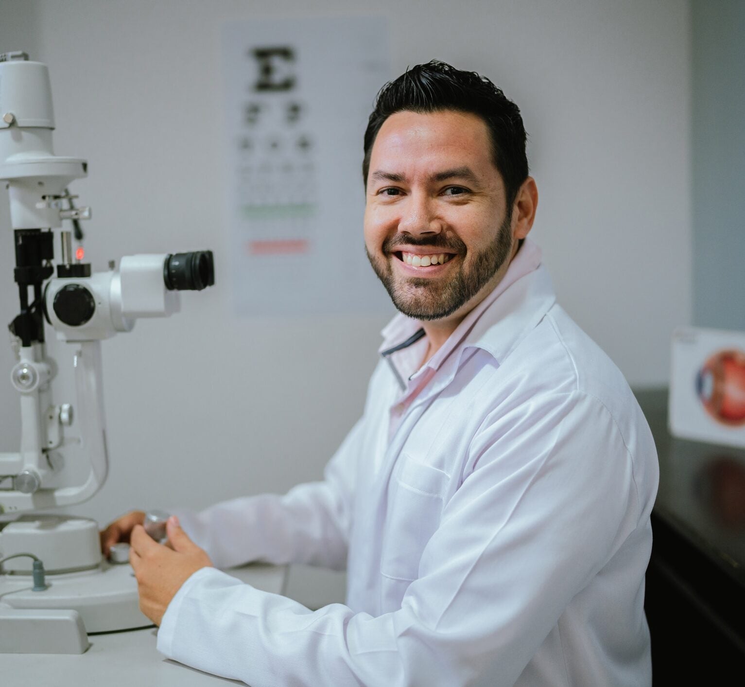 Portrait of a mid adult ophthalmologist man doing exam on patient at medical clinic